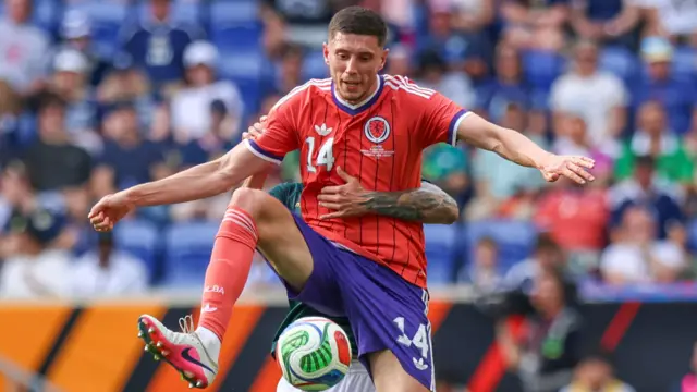 Ross Stewart, wearing Scotland's red away shirt with white and blue trim, in action against Bolivia on 6 June.