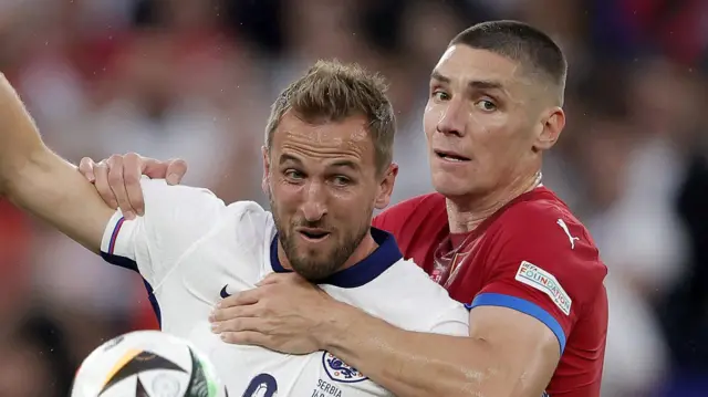 Nikola Milenkovic grapples with Harry Kane during the Euro 2024 match between Serbia and England