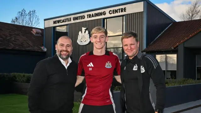 Anthony Gordon, Eddie Howe and Paul Mitchell pose for a photo together at Newcastle's training ground