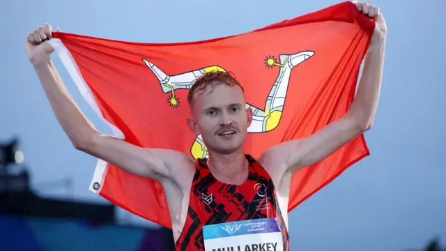 David Mullarkey holding the Isle of Man flag above his head