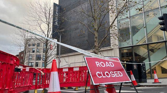 A road closed sign with bollards and cones outside Exeter's John Lewis building.