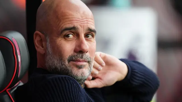 Pep Guardiola looks on from the dugout