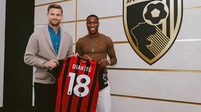 Simon Francis presents a shirt to Diakite as he signs for Bournemouth