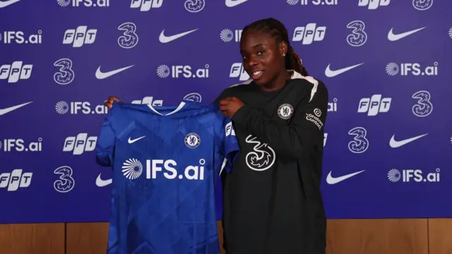 Sandy Baltimore holding Chelsea shirt 