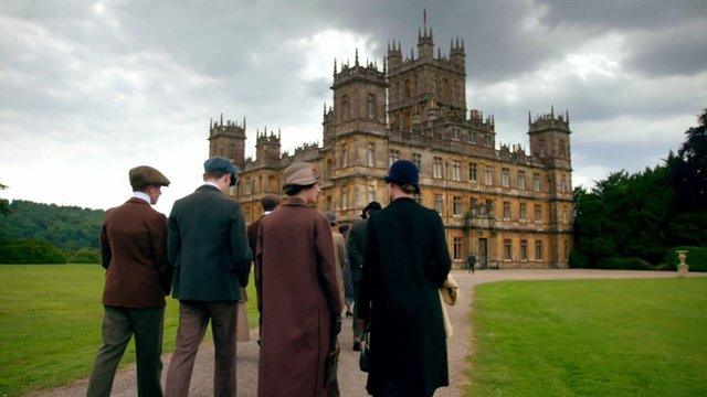 Characters walking towards Downton Abbey