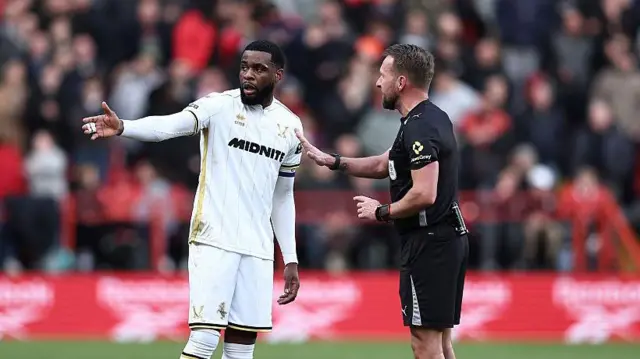 Sheffield United captain Japhet Tanganga interacts with referee Oliver Langford after he was sent off for a dangerous challenge against Charlton Athletic.