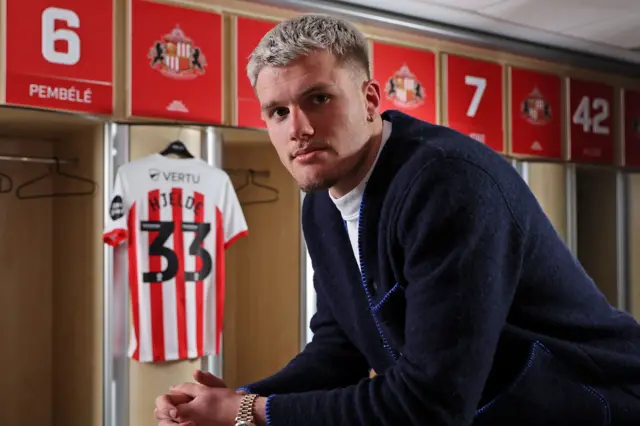 Leo Hjelde with his new Sunderland shirt behind him