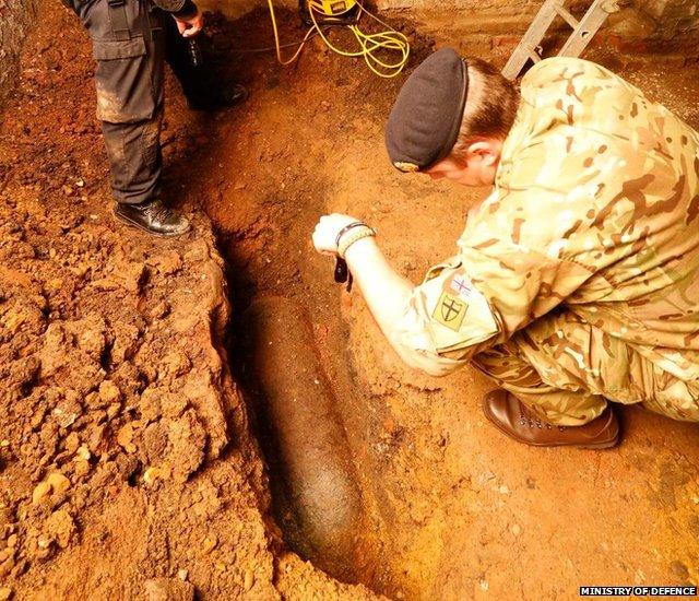 Bomb disposal experts examine the unexploded WW2 bomb