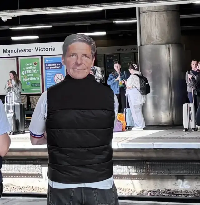 A fan wears an Oliver Glasner mask