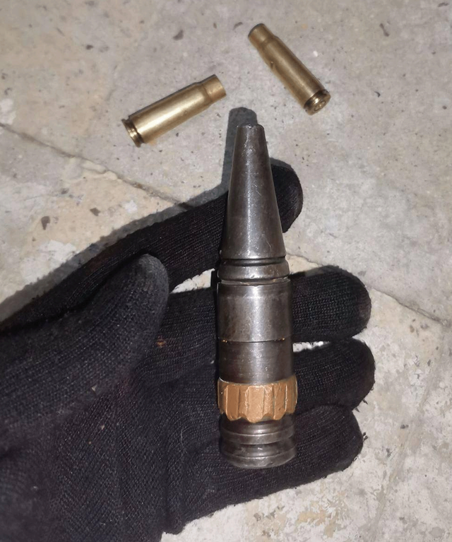 Një pamje e ekranit nga një video e verifikuar tregon një dorë me doreza të zeza që shfaq një predhë të madhe të zezë të përdorur si top automatik 20 mm, me shenja pushke në shirtin e saj drejtues, ndërsa dy gëzhoja të përdorura nga një pushkë sulmi Kalashnikov AK-47 ndodhen mbi pllaka poshtë.