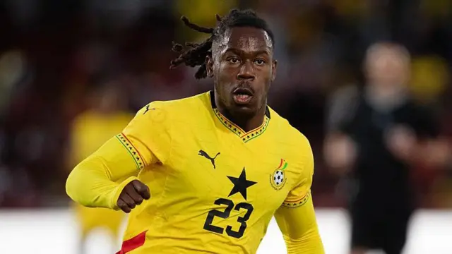 Brandon Thomas-Asante in action wearing a yellow Ghana shirt with a black star in the middle and the number 23 in black underneath it