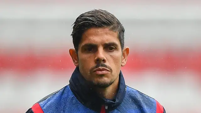 A close-up of Guilherme Ramos standing in the rain while he was assistant manager at Nottingham Forest
