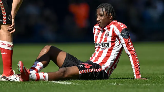 Sunderland winger Romaine Mundle sitting on the turf at The Hawthorns after suffering a hamstring injury against West Bromwich Albion
