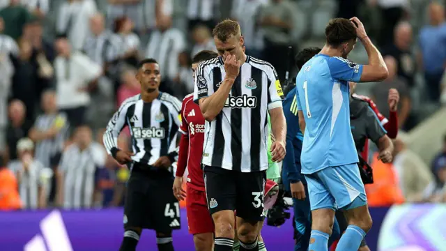 Dan Burn of Newcastle United looks dejected after the defeat by Liverpool