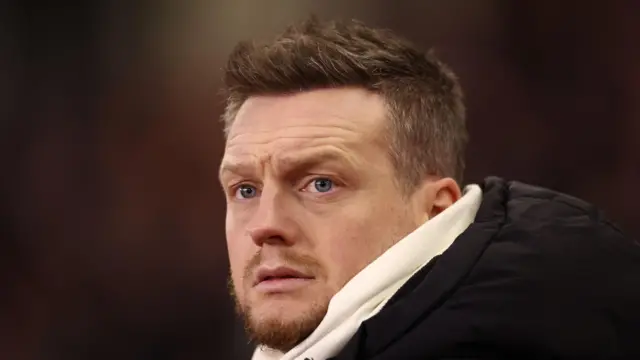 Kim Hellberg, wearing a big black coat with a white scarf, watching Middlesbrough play