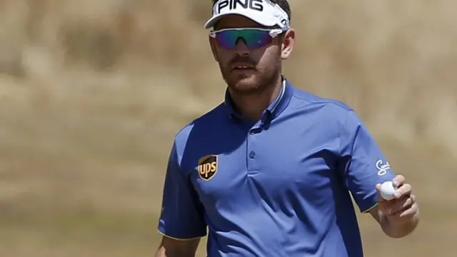 Louis Oosthuizen holds up his ball