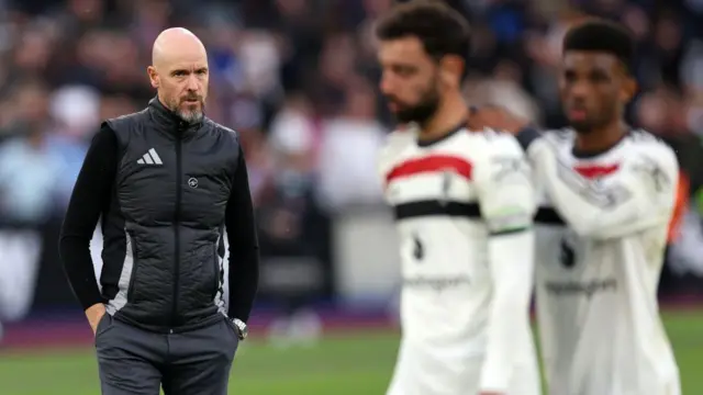 Erik ten Hag, Bruno Fernandes and Amad Diallo stand on the field after the defeat at West Ham