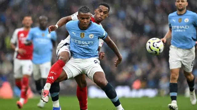 Man City's Manuel Akanji and Arsenal's Jurrien Timber battle for the ball