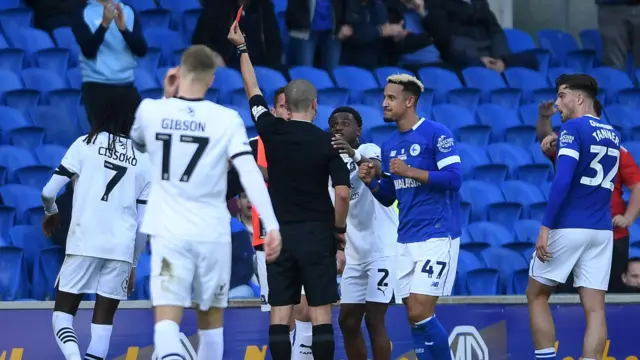 Referee Andrew Kitchen shows Plymouth's Ibrahim Cissoko a red card