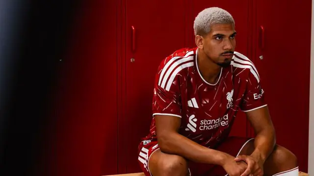 Ronald Araujo sits in a Liverpool kit after signing