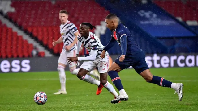 Kylian Mbappe of Paris Saint-Germain is tackled by Aaron Wan Bissaka of Manchester United