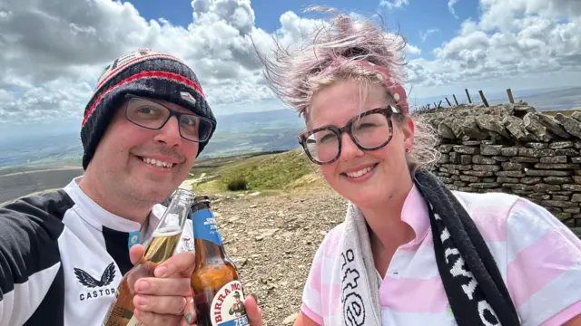 Newcastle fans celebrate at the top of Pen-y-Ghent in the Yorkshire Dales