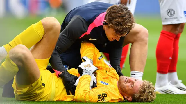 Portsmouth goalkeeper Nico Schmid being attended to after going down injured