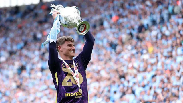 Carl Rushworth holds the Championship trophy aloft