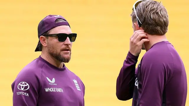 Brendon McCullum (left, facing camera) speaking to Joe Root