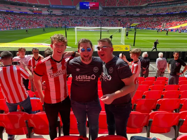 Teenager and two men at Wembley in Brentford shirts