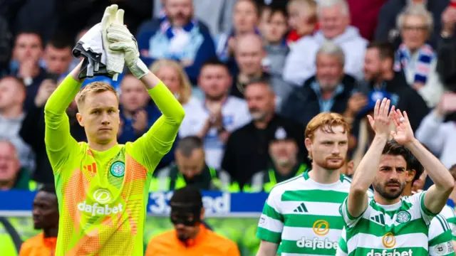Celtic's Viljami Sinisalo (L) and Greg Taylor applaud fans as they walk out onto the pitch during a William Hill Premiership match between Rangers and Celtic at Ibrox