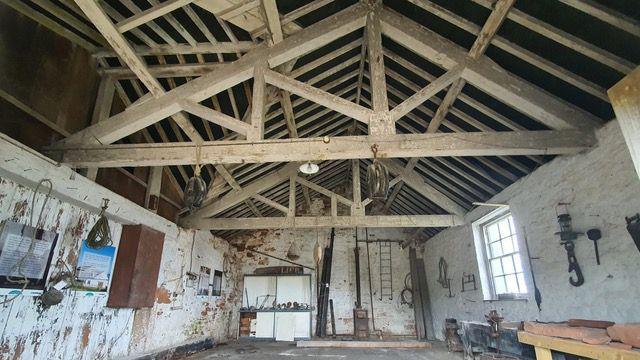 Inside one of the building on the island, the ceiling beams are exposed and the paint is peeling off the walls