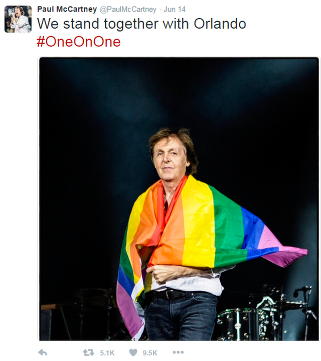 Paul McCartney draped in rainbow flag