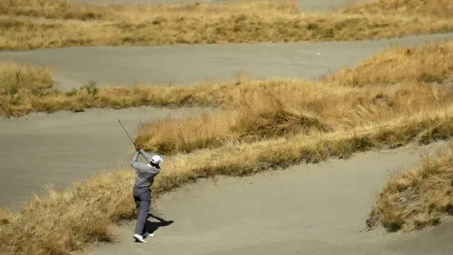 Tiger Woods hits out of the bunker