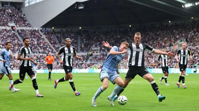 Dejan Kulusevski of Tottenham Hotspur under pressure from Dan Burn of Newcastle United