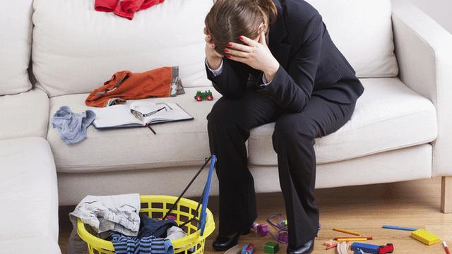 Woman with head in hands in messy room