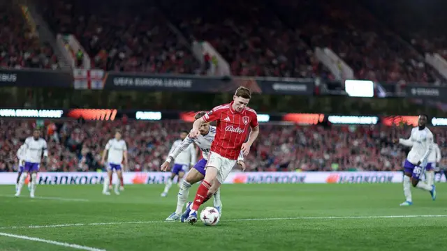 Elliot Anderson dribbles with the ball under pressure from Matty Cash
