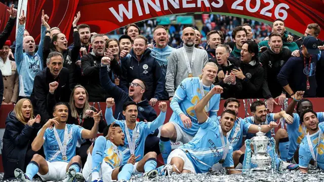 Manchester City players celebrate with FA Cup trophy