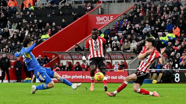 Ao Tanaka of Leeds United shoots over the bar under pressure from Trai Hume and Lutsharel Geertruida