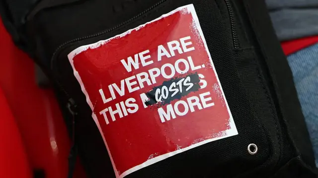 A sticker reads 'We are Liverpool. This costs more.'