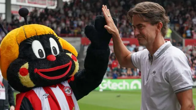 Thomas Frank high-fives Brentford's mascot