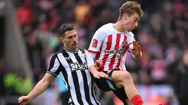 Newcastle United's Fabian Schar and Jack Clarke of Sunderland battle for the ball in an FA Cup tie in 2024