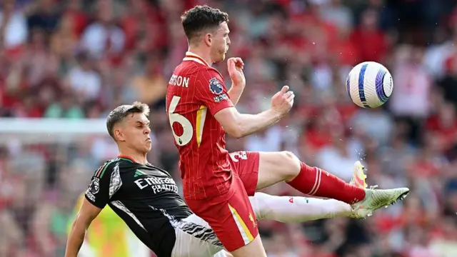 Leandro Trossard and Andy Robertson compete for the ball