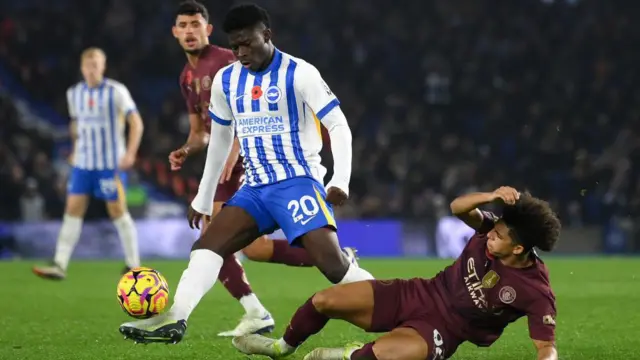 Brighton's Carlos Baleba battles for possession with Manchester City's Rico Lewis