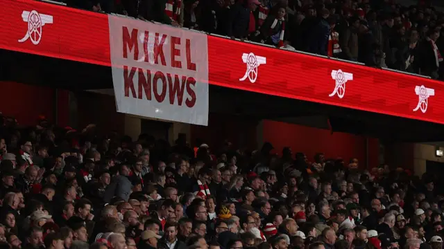 A banner in the Arsenal crowd that reads "Mikel Knows"