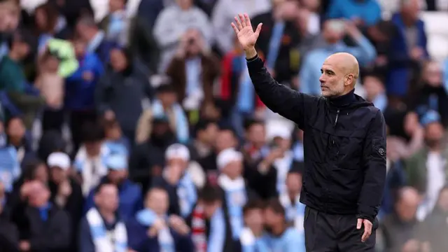 Manchester City boss Pep Guardiola waves to fans