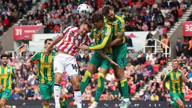 Nat Phillips and Chris Mepham leap to try and win a header against Stoke's Ben Wilmot