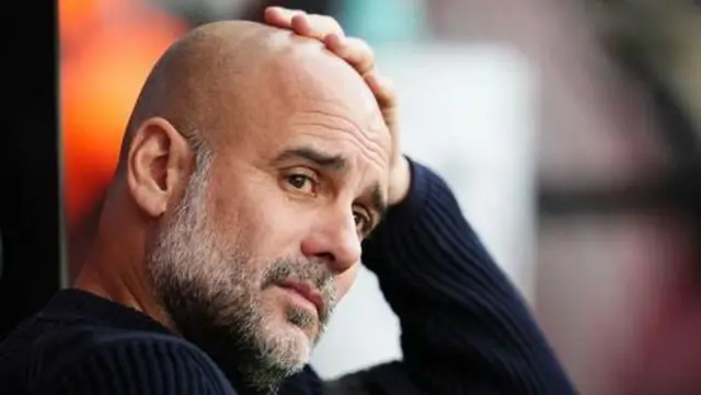 Pep Guardiola of Manchester City sat in the dugout