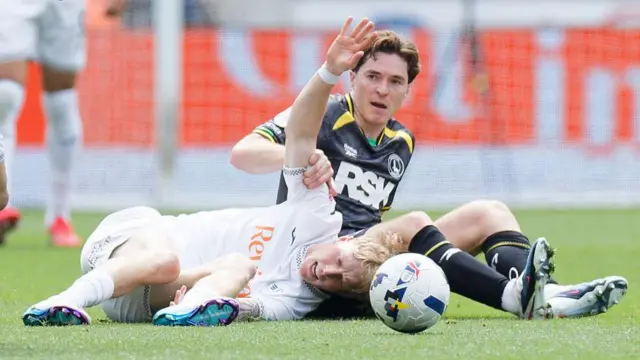 Melker Widell holds his hand in the air after a heavy challenge from Conor Coventry 