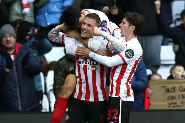 Dan Ballard celebrating after scoring against West Brom at the Stadium of Light with Luke O'Nien on his back and Trai Hume behind them